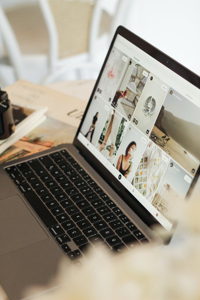 Open laptop showing an image gallery on a wooden table, perfect for technology and workspace themes.